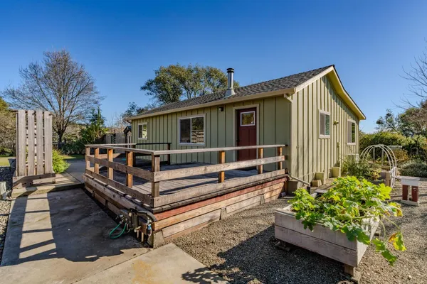 a view of wooden house with a yard