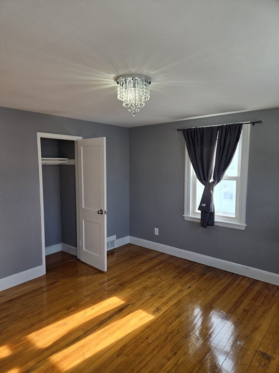 114 Faraday Street, Unit 2 Boston, MA 02136 - Photo 23 of 25 a view of an empty room with window and wooden floor