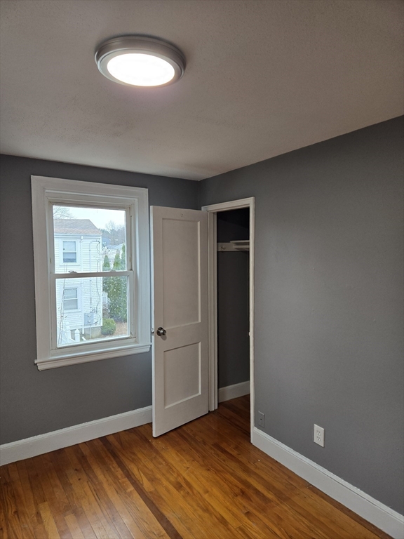 114 Faraday Street, Unit 2 Boston, MA 02136 - Photo 25 of 29 an empty room with wooden floor and windows