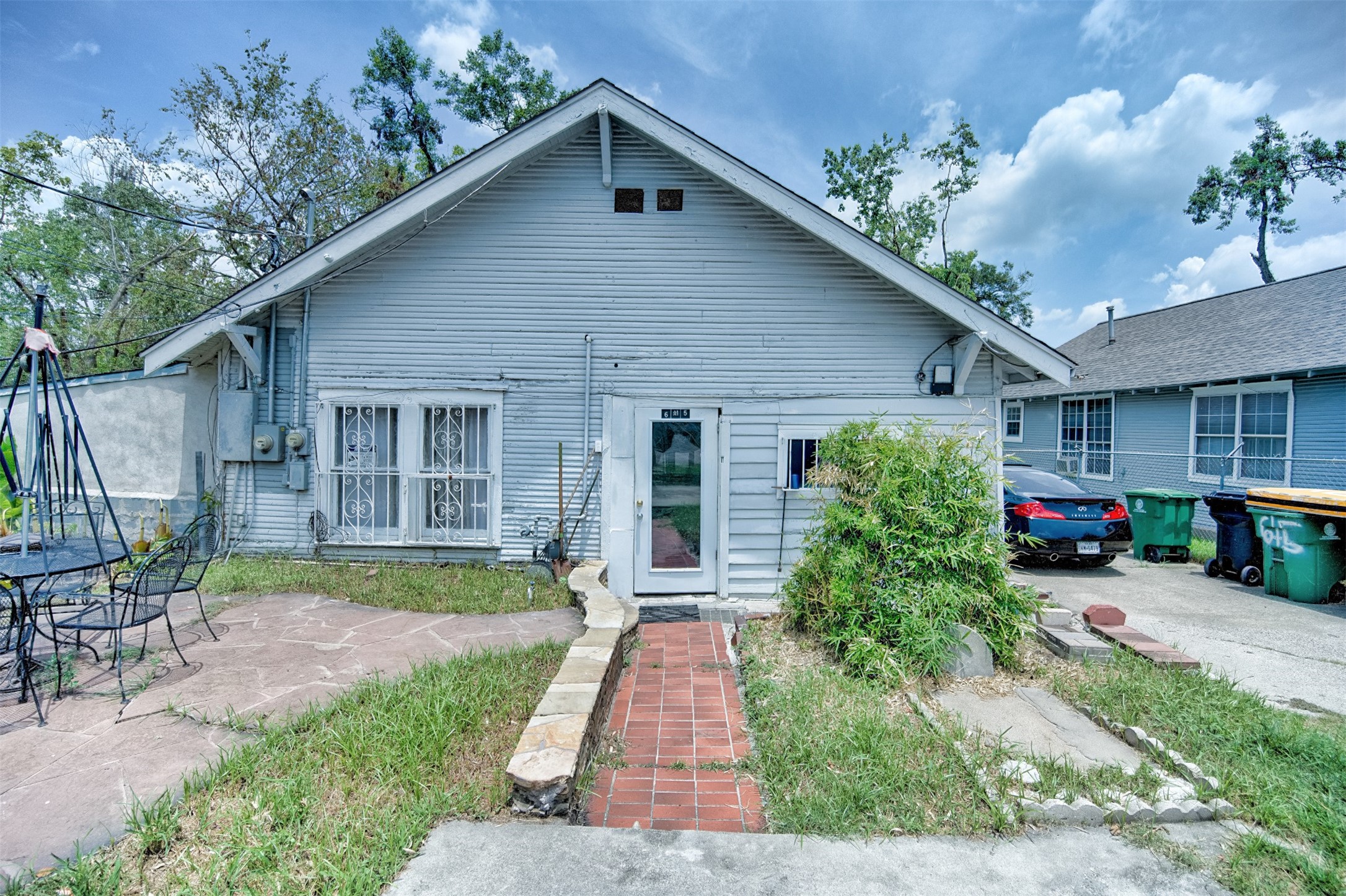 a front view of a house with a yard and potted plants