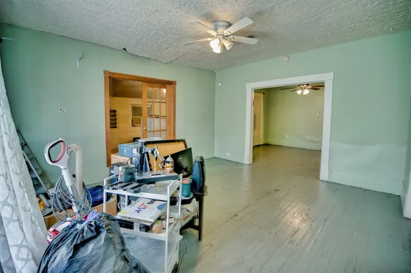 wooden floor with chandelier fan and living room