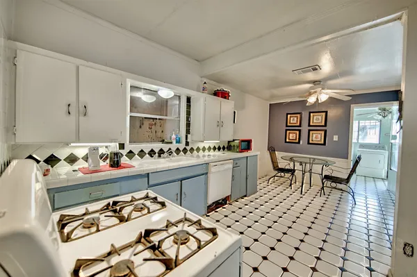 a kitchen that has a lot of cabinets a sink and a dining table view