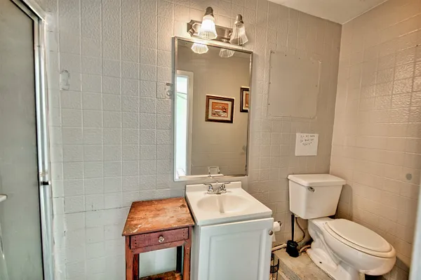 a bathroom with a toilet sink and mirror