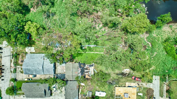 an aerial view of residential house with outdoor space and trees all around