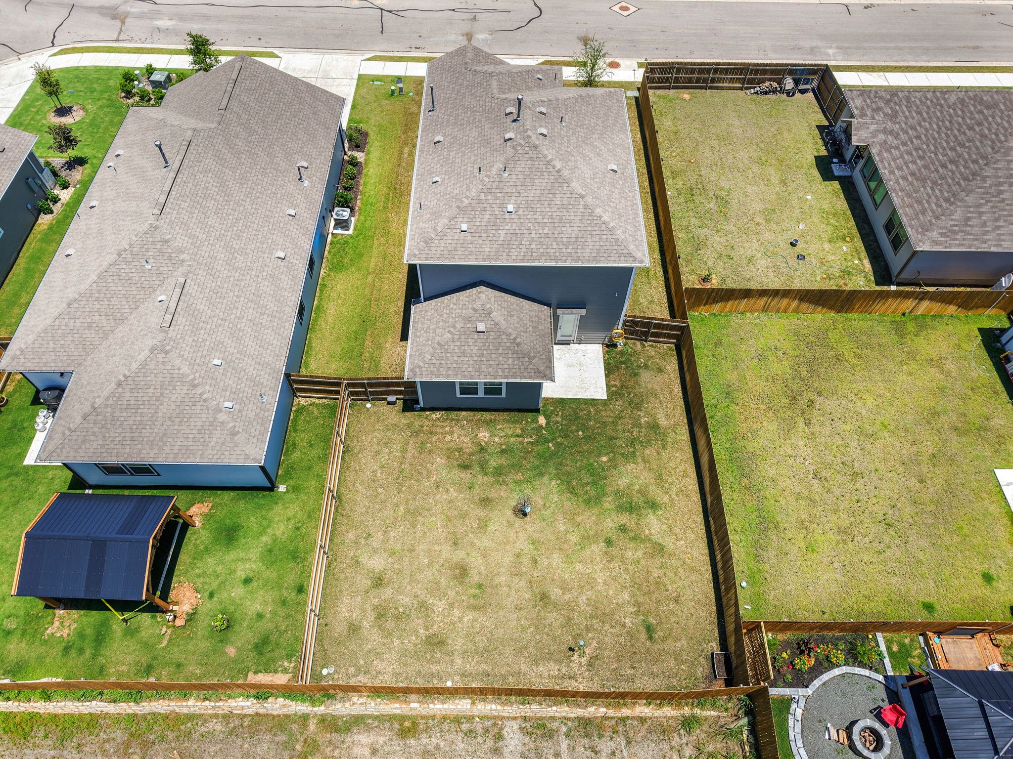148 Hidalgo Lane Elgin, TX 78621 - Photo 33 of 38 An aerial perspective reveals the neighborhood setting, fenced yards, and a fire pit.