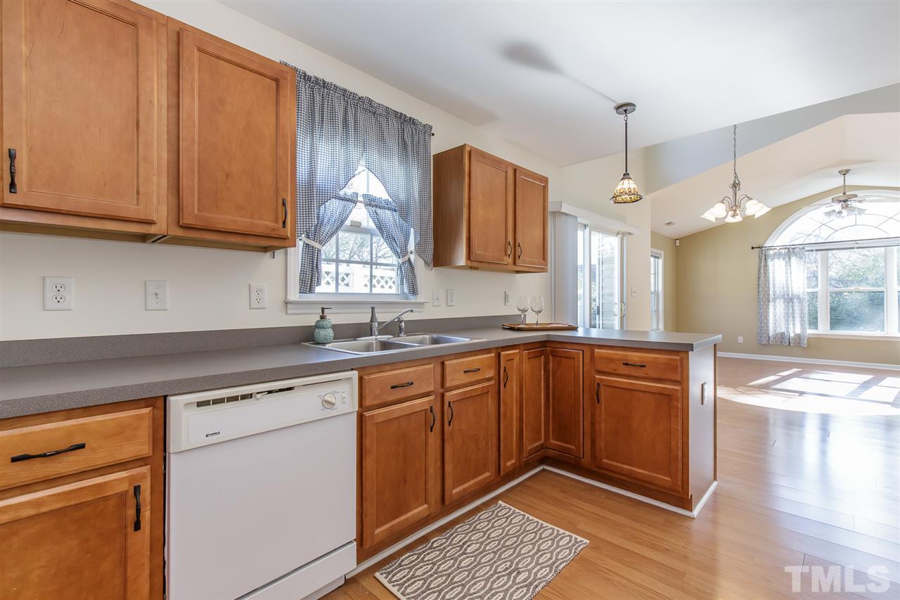 4105 Neal Road, Unit C Durham, NC 27705 - Photo 8 of 22 a kitchen with granite countertop wooden cabinets stainless steel appliances a sink and a window