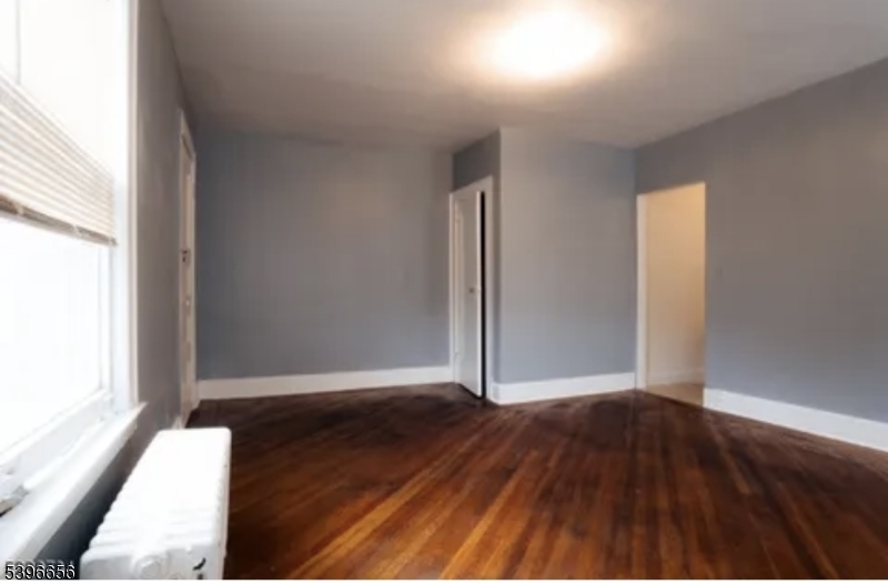 26 Dodd Street Bloomfield, NJ 07003 - Photo 3 of 5 an empty room with wooden floor and windows