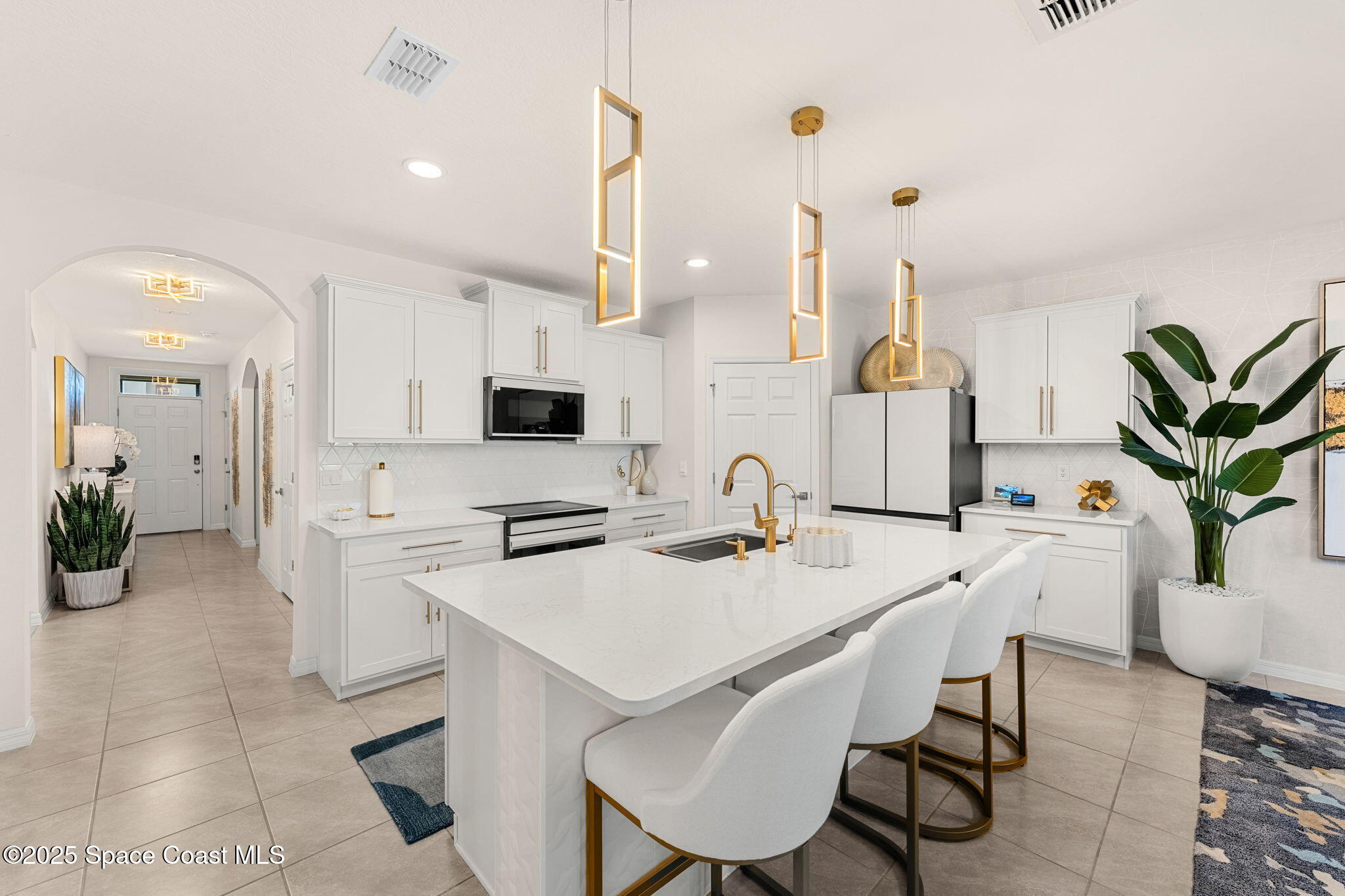 2013 Farmhouse Road Southeast Palm Bay, FL 32909 - Photo 11 of 37 a kitchen with stainless steel appliances a white table chairs and a refrigerator