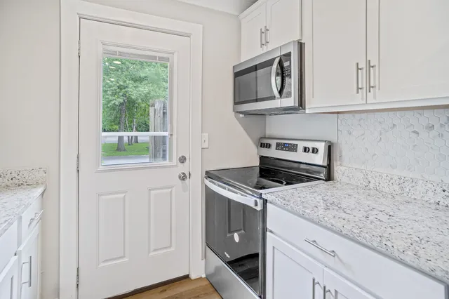 a kitchen with white cabinets and appliances