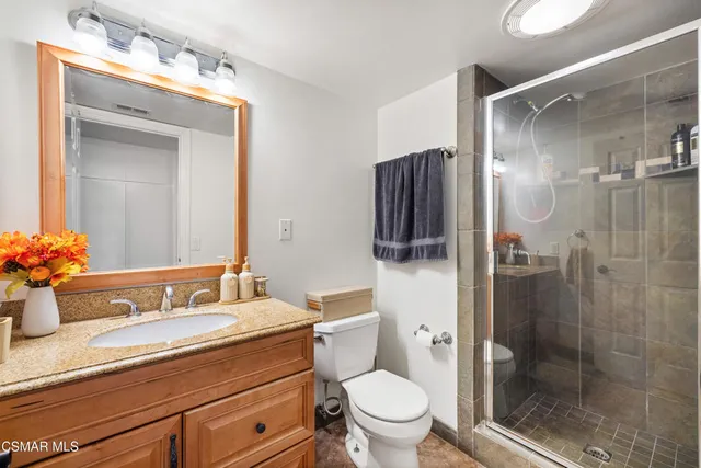 a bathroom with a granite countertop sink toilet and shower