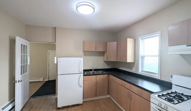 a kitchen with a refrigerator a stove and a window