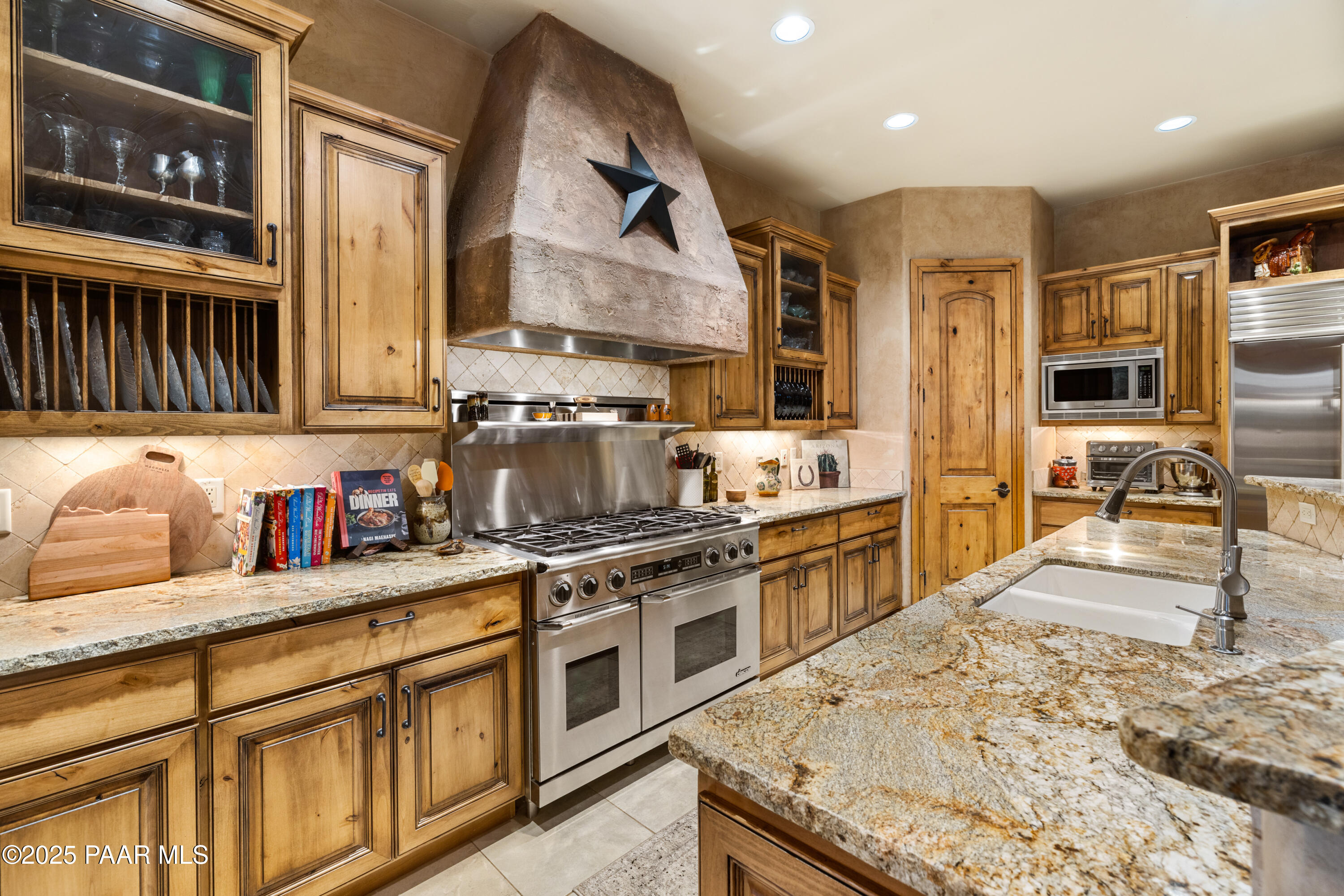5110 Indian Camp Road Prescott, AZ 86305 - Photo 11 of 79 a kitchen with stainless steel appliances granite countertop a stove top oven a sink a dining table and chairs