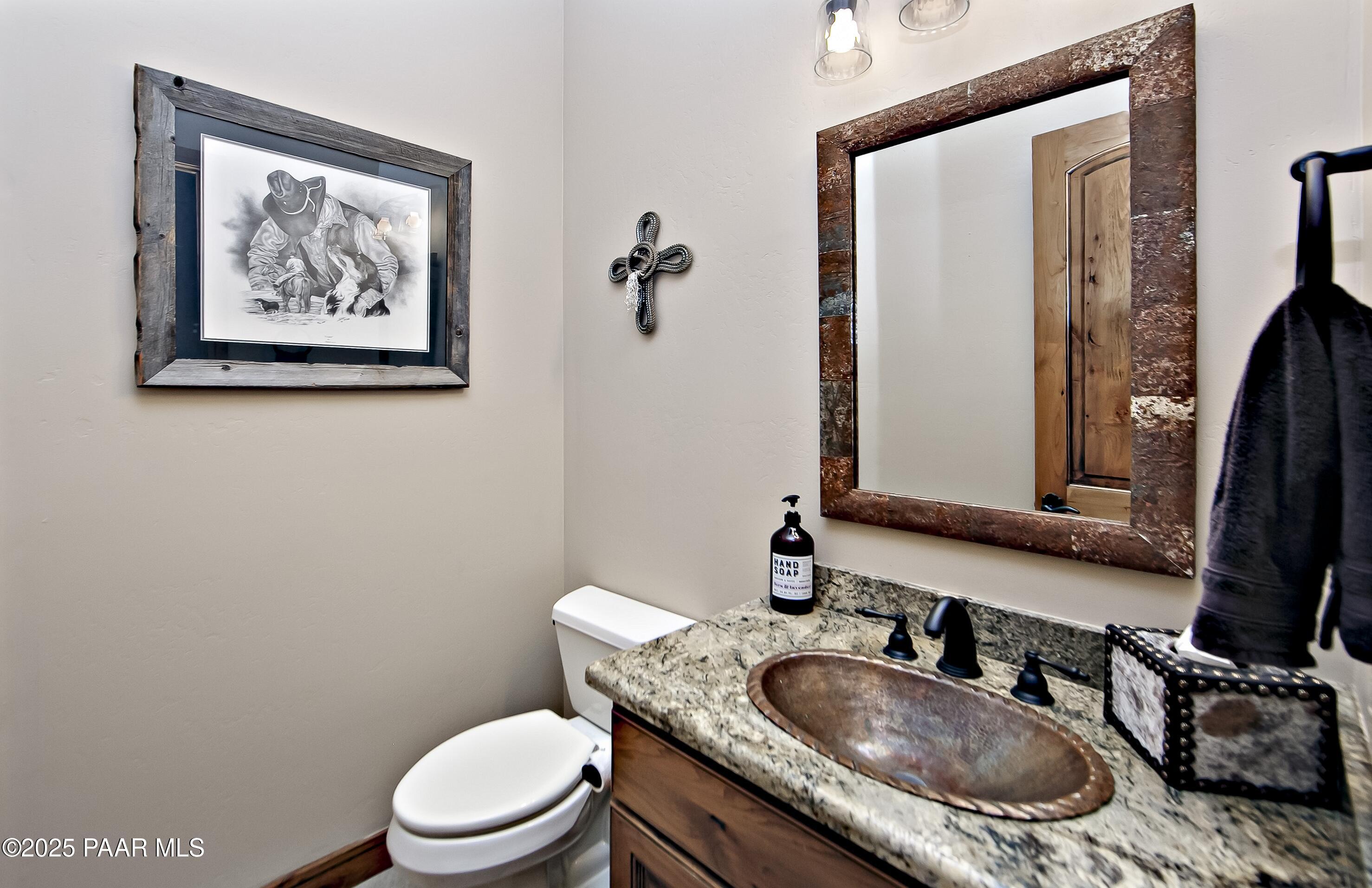 5110 Indian Camp Road Prescott, AZ 86305 - Photo 33 of 79 a bathroom with a granite countertop toilet a sink and mirror