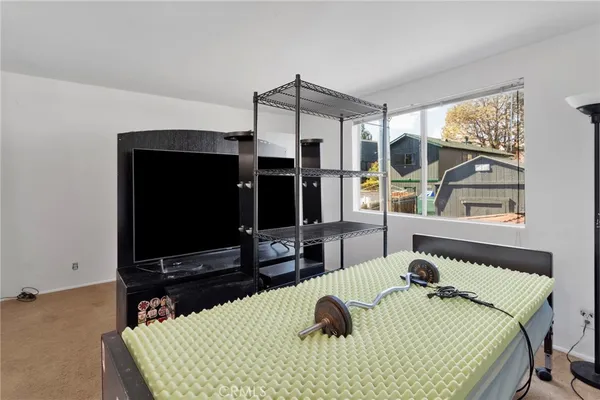 a bedroom with a bed window and flat screen tv