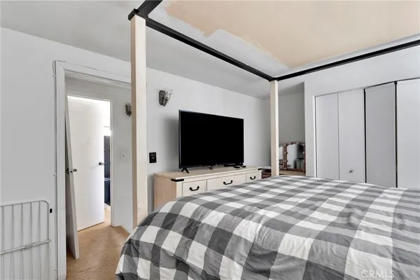 a bedroom with a bed and a flat screen tv