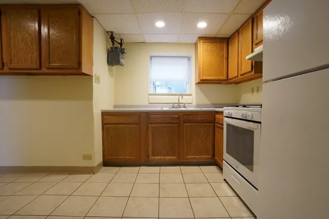 a kitchen with a sink a stove top oven and cabinets