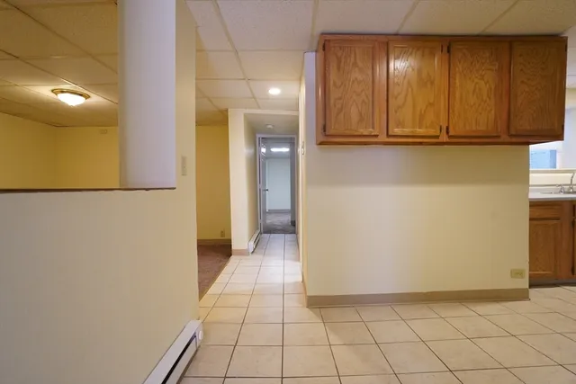 a view of a hallway with wooden floor and cabinet