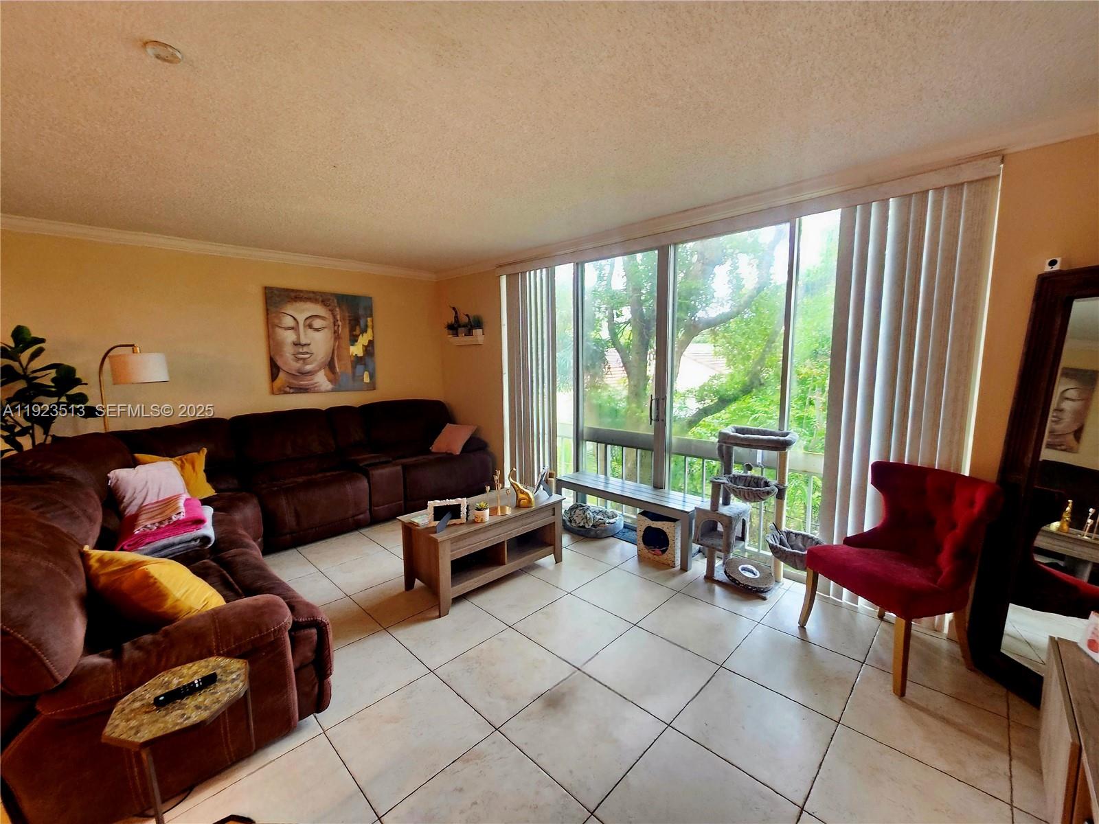 8401 West Sample Road, Unit 10 Coral Springs, FL 33065 - Photo 4 of 17 a living room with furniture and a floor to ceiling window