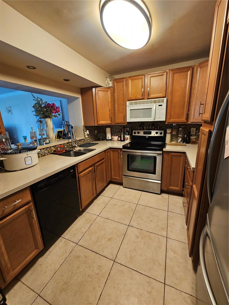 8401 West Sample Road, Unit 10 Coral Springs, FL 33065 - Photo 6 of 17 a kitchen with stainless steel appliances granite countertop a sink stove and cabinets