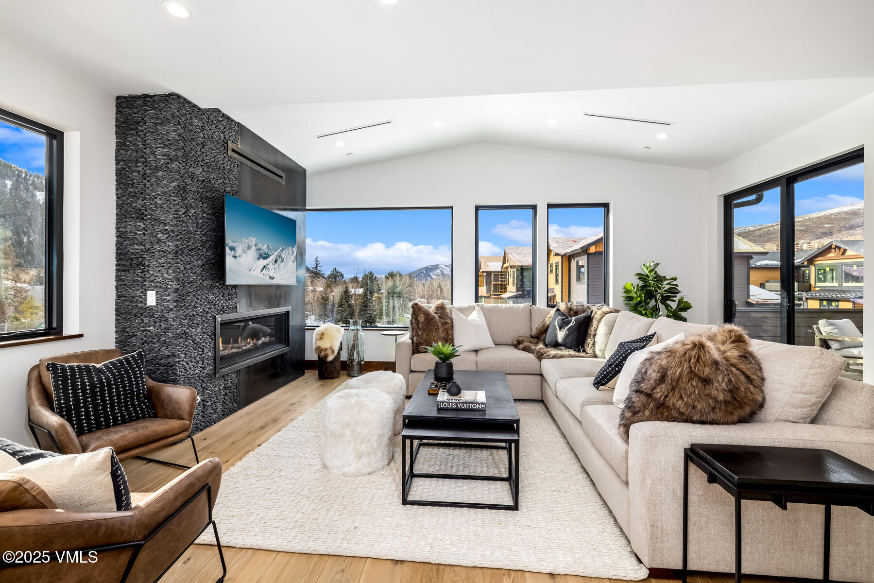 a living room with furniture fireplace and a large window