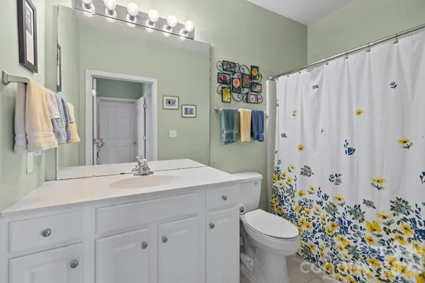 a bathroom with a sink a toilet and shower curtain