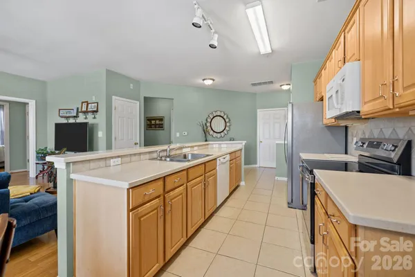 a large kitchen with stainless steel appliances kitchen island granite countertop a sink and cabinets
