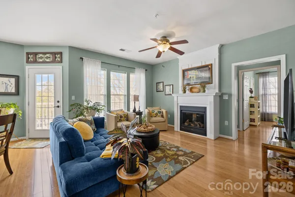 a living room with furniture fireplace and a large window