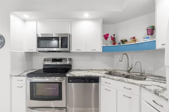 a bedroom with a bed and a large mirror on the dresser