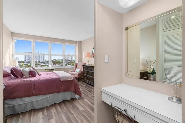 a bedroom with a bed and a potted plant on the dresser