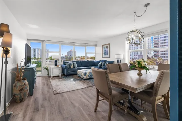 a living room with furniture kitchen view and a chandelier