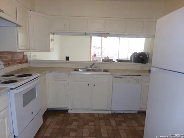 a kitchen with a sink cabinets and appliances
