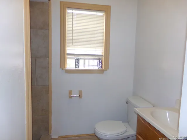 a white toilet sitting next to a bath tub