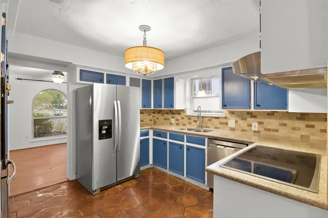 a kitchen with stainless steel appliances a stove a refrigerator and a sink
