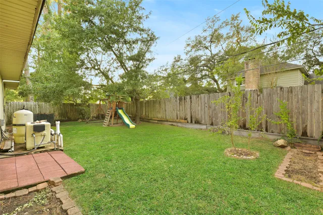 a view of a backyard with table and chairs and wooden fence