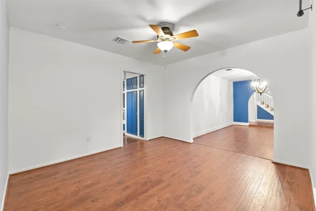 a view of a livingroom with a chandelier fan and a window