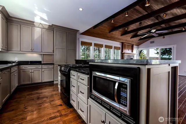 a kitchen with a stove and a wooden floor