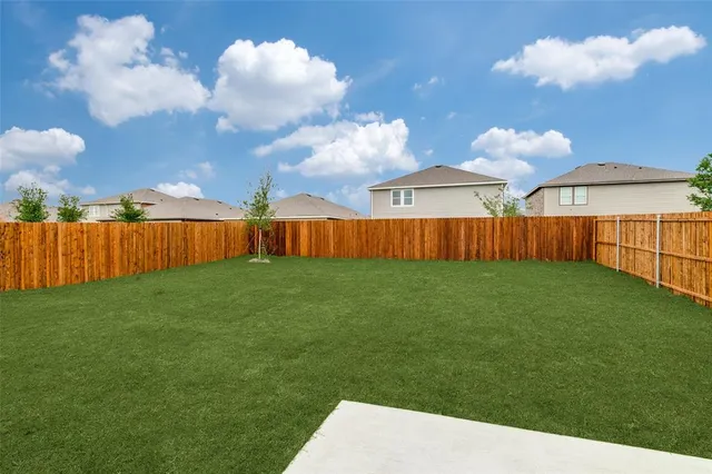 a view of a backyard with dishwasher and wooden fence