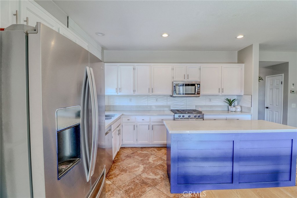 729 Windbound Avenue Beaumont, CA 92223 - Photo 23 of 73 a kitchen with a refrigerator sink and cabinets