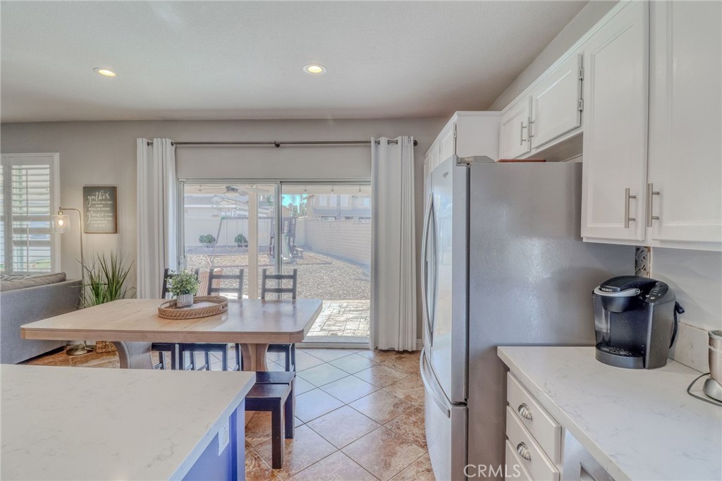 729 Windbound Avenue Beaumont, CA 92223 - Photo 24 of 73 a kitchen with stainless steel appliances granite countertop a refrigerator and a dining table