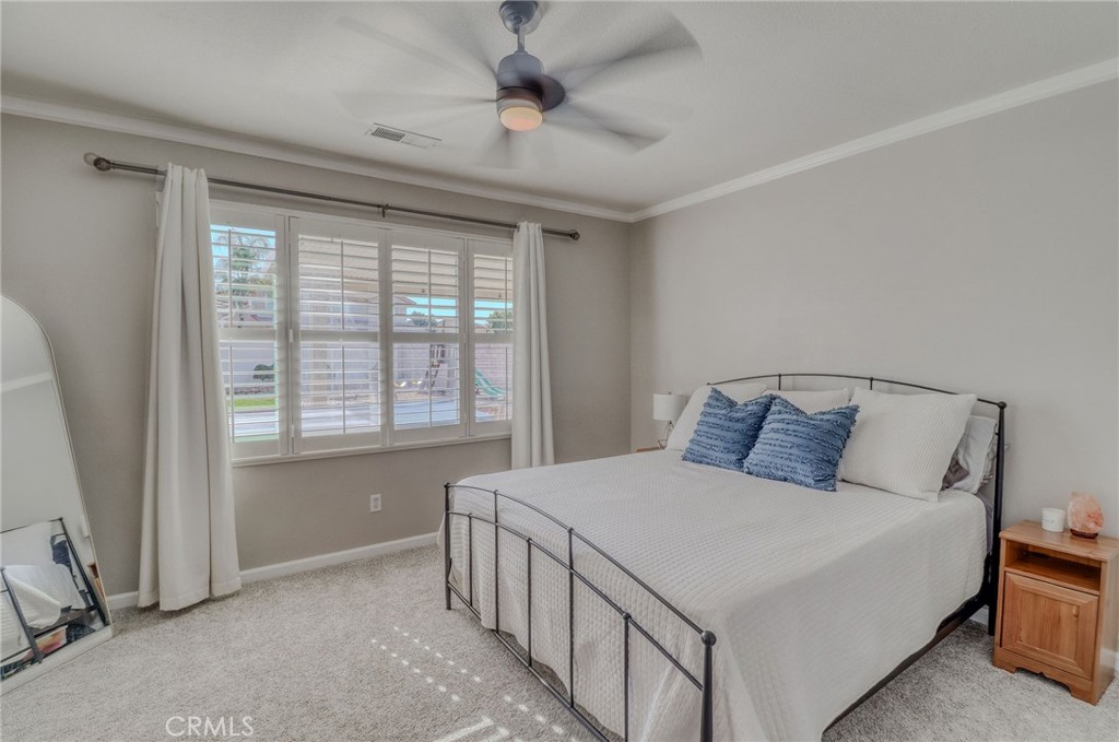 729 Windbound Avenue Beaumont, CA 92223 - Photo 35 of 73 a bedroom with a large bed and a chandelier fan