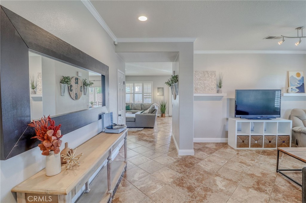 729 Windbound Avenue Beaumont, CA 92223 - Photo 10 of 73 a living room with furniture a flat screen tv and kitchen view