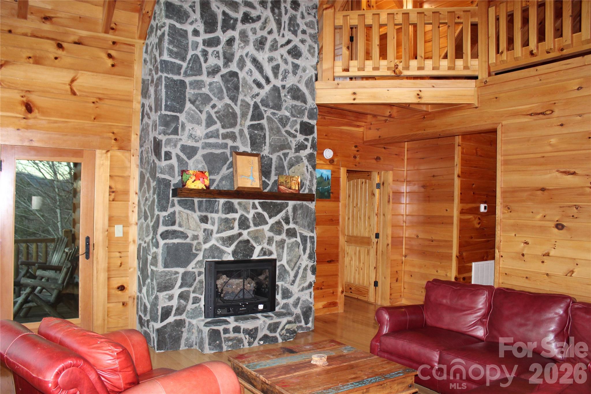 169 Overlook Point Lane Lake Lure, NC 28746 - Photo 12 of 39 a living room with furniture a flat screen tv and a fireplace