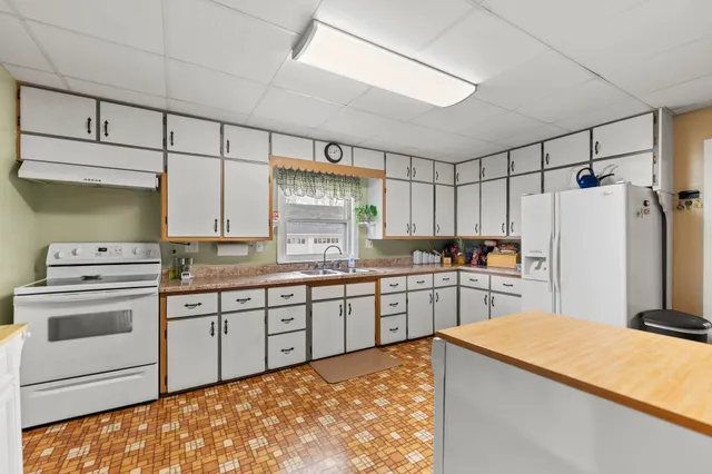 a kitchen with refrigerator and cabinets