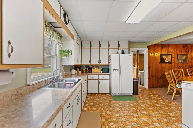 a kitchen with white cabinets and refrigerator