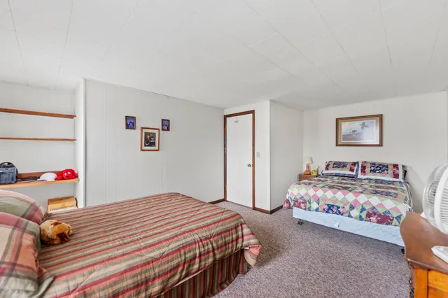 a bedroom with bed and paintings on the wall