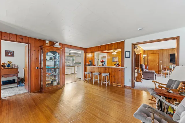 a living room with furniture floor to ceiling window and wooden floor