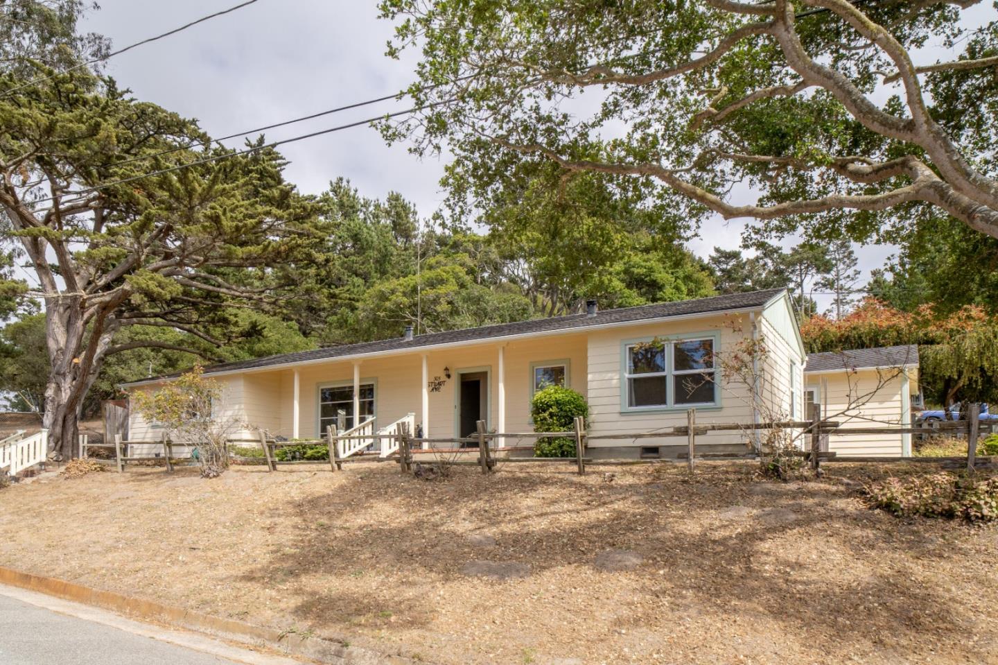 a front view of house with yard and trees in the background