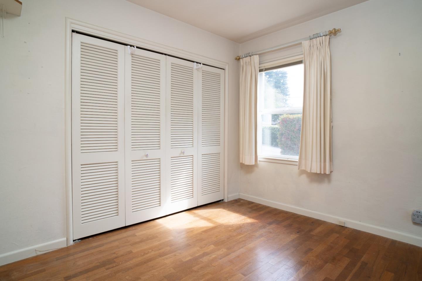 305 Stuart Avenue Pacific Grove, CA 93950 - Photo 13 of 24 an empty room with wooden floor and windows