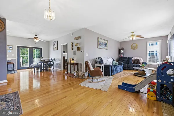 a view of a livingroom with furniture staircase and a kitchen view of a chandelier