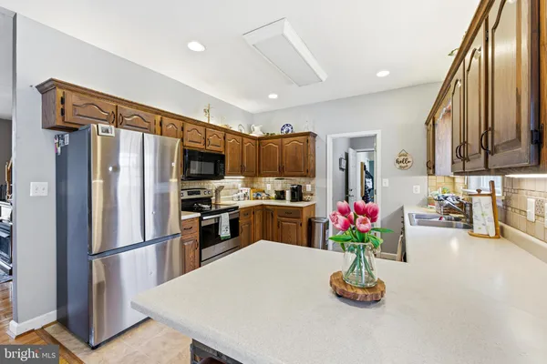 a kitchen with stainless steel appliances a refrigerator sink microwave and cabinets